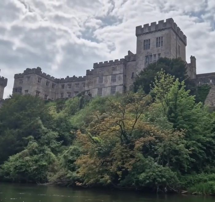 Lismore Castle rising above the wooded riverbank