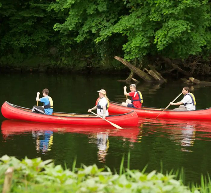 A family paddling a canoe together on the river